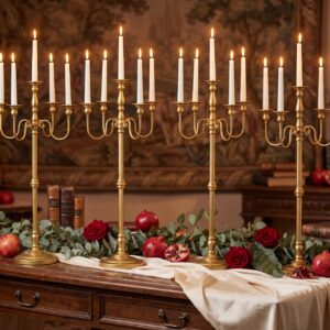 Tall gold candelabra with multiple white taper candles beside a rustic table decorated with red roses and greenery for a classic proposal dinner